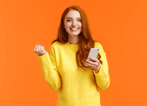 Kobieta w żółtym swetrze z telefonem w ręku